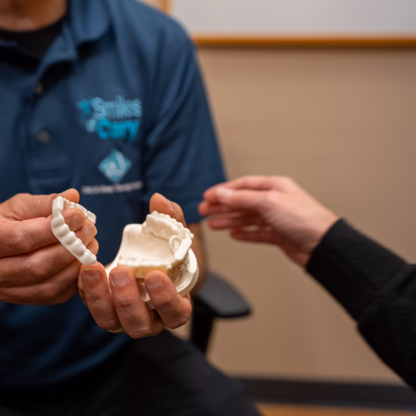 Dr. Charles Ferzli showing a patient a model of her bite at Smiles of Cary