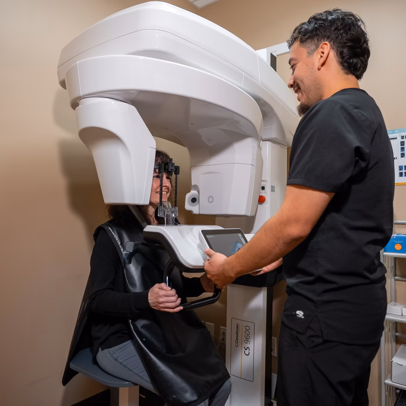A team member positioning a patient for a 3D dental imaging scan at Smiles of Cary