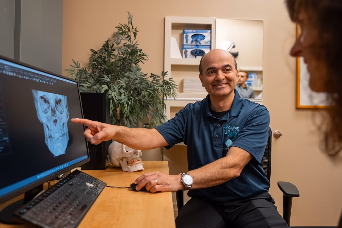 Dr. Charles Ferzli pointing out a 3D scan on his monitor during a consultation at Smiles of Cary