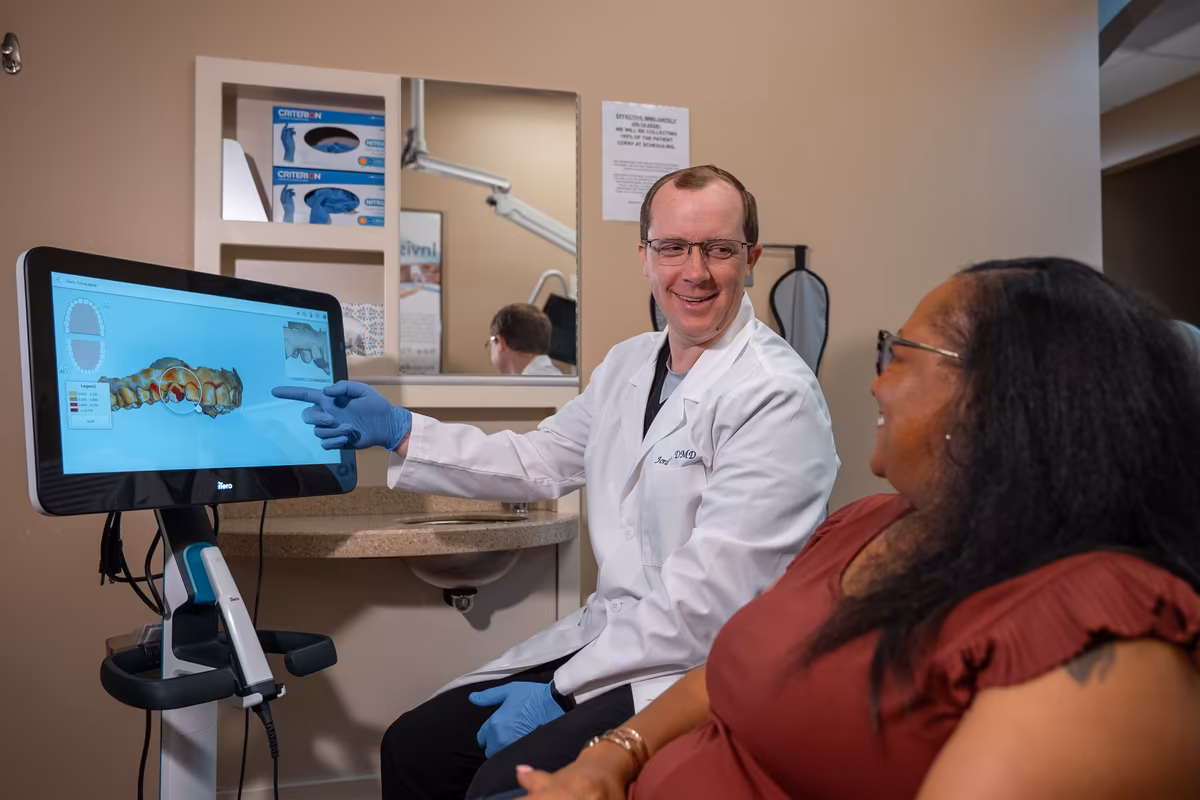Dr. Jordan Lee reviewing a 3D scan of a patient&rsquo;s teeth with her at Smiles of Cary