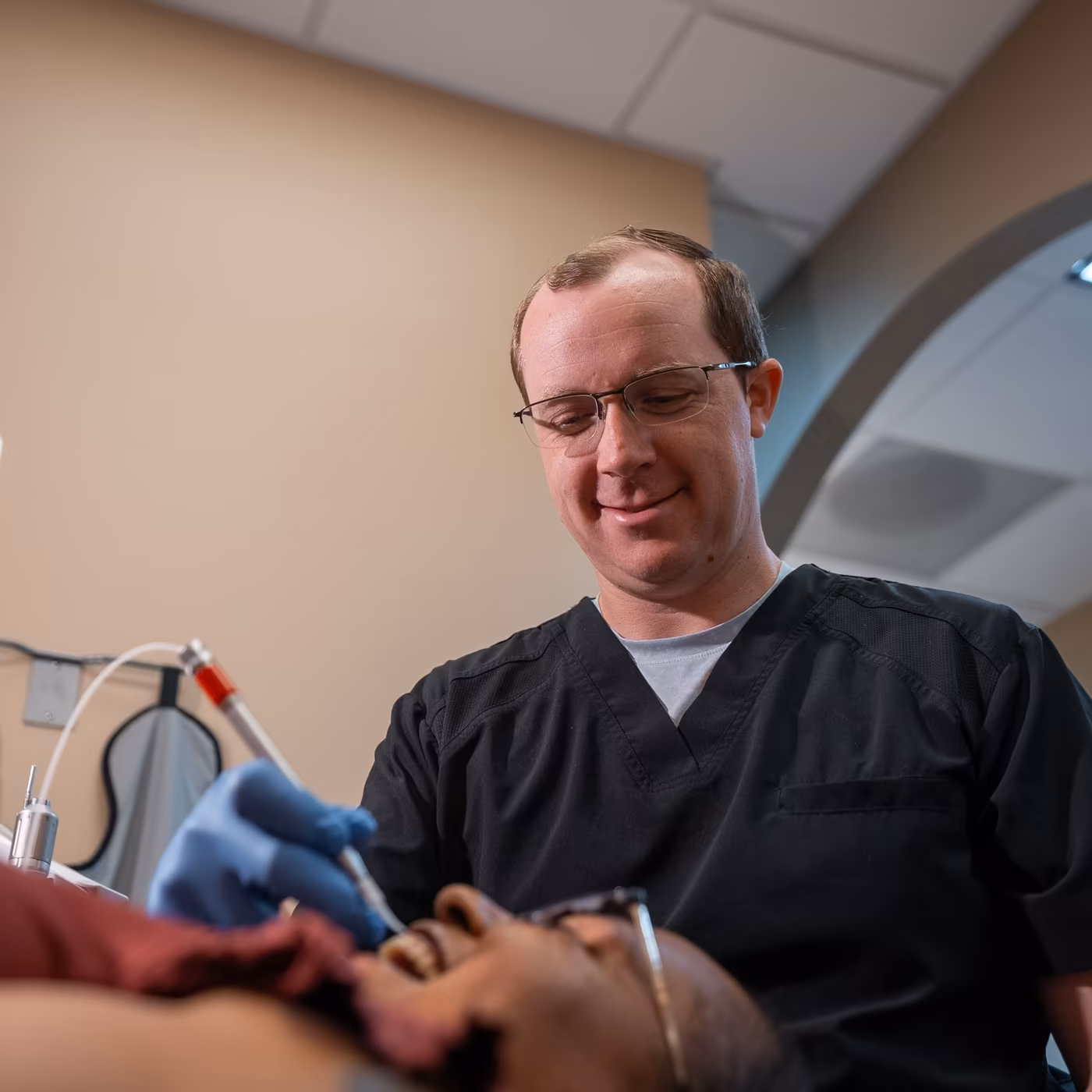 Dr. Jordan Lee examining a patient's teeth chairside at Smiles of Cary