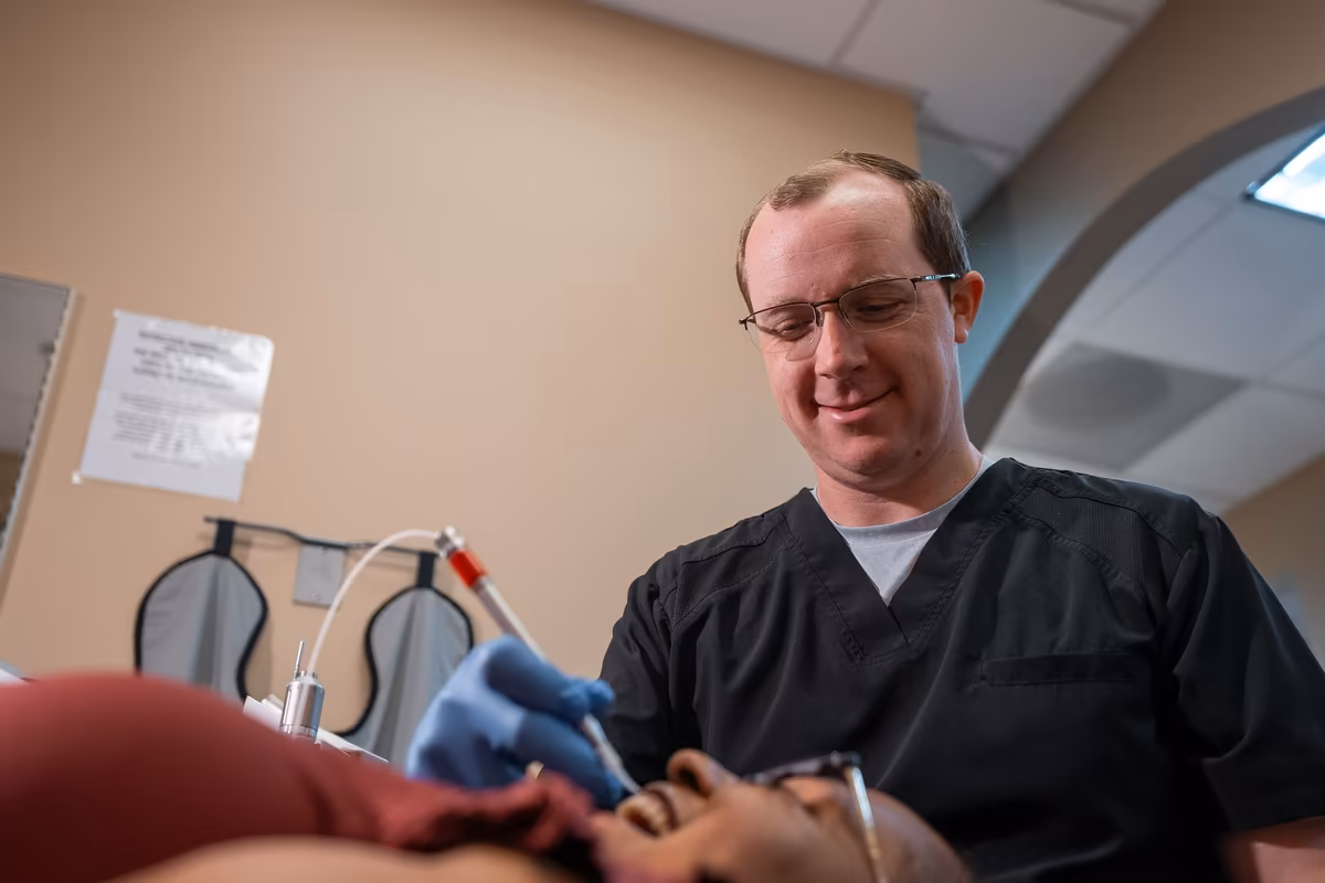 Dr. Jordan Lee examining a patient's teeth chairside at Smiles of Cary