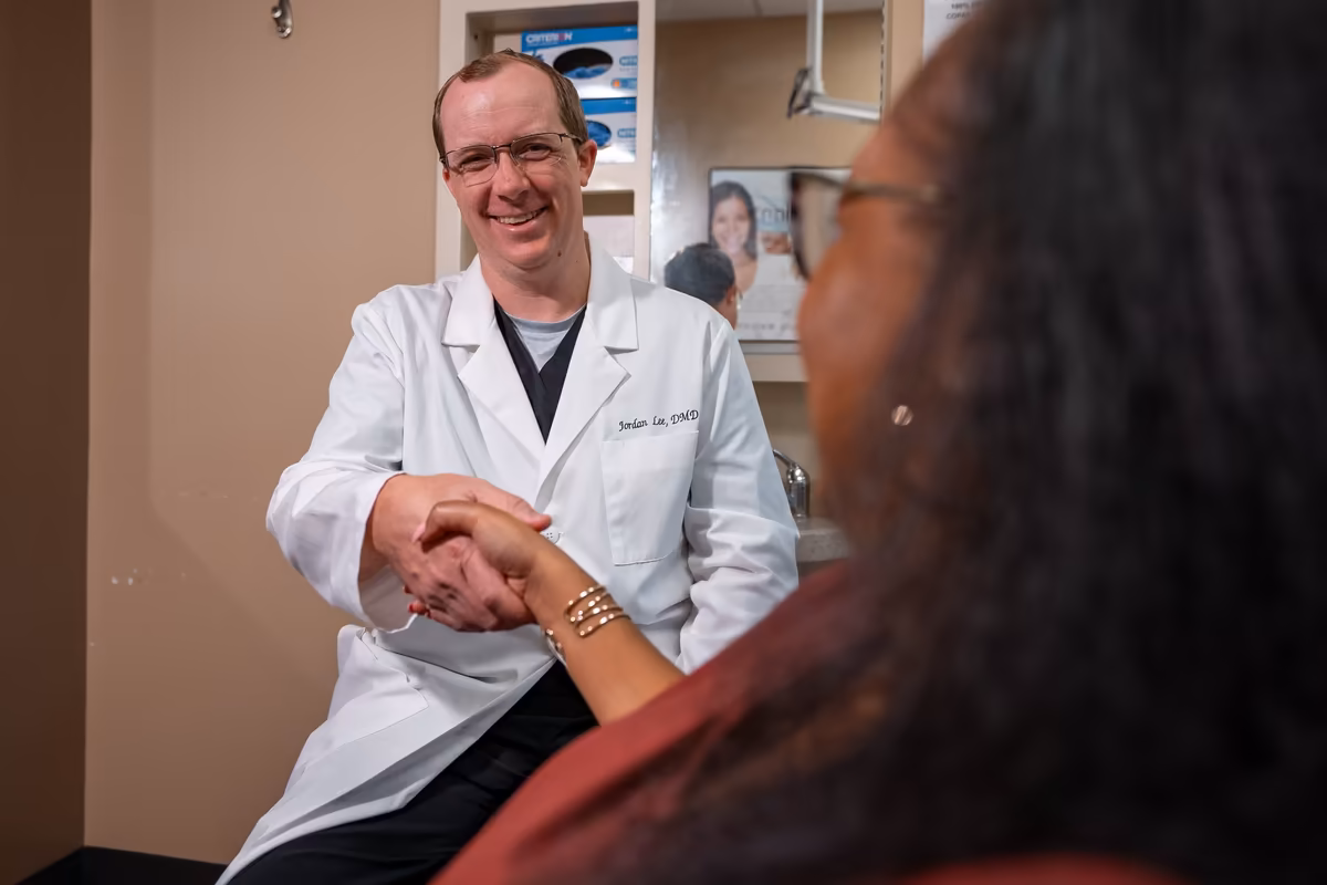 Dr. Jordan Lee shaking hands with a patient chairside at Smiles of Cary