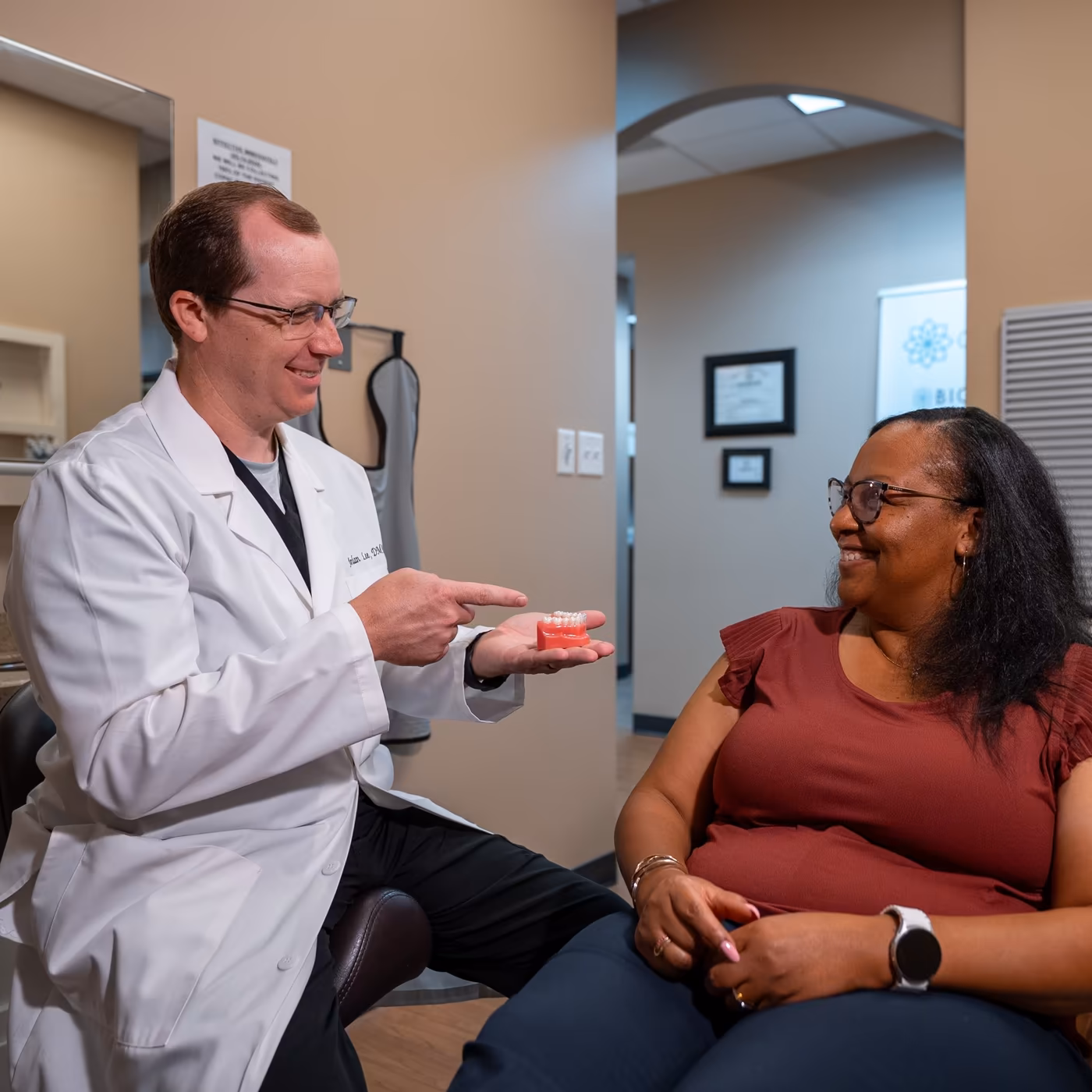 Dr. Jordan Lee explaining treatment with a dental model to a patient at Smiles of Cary