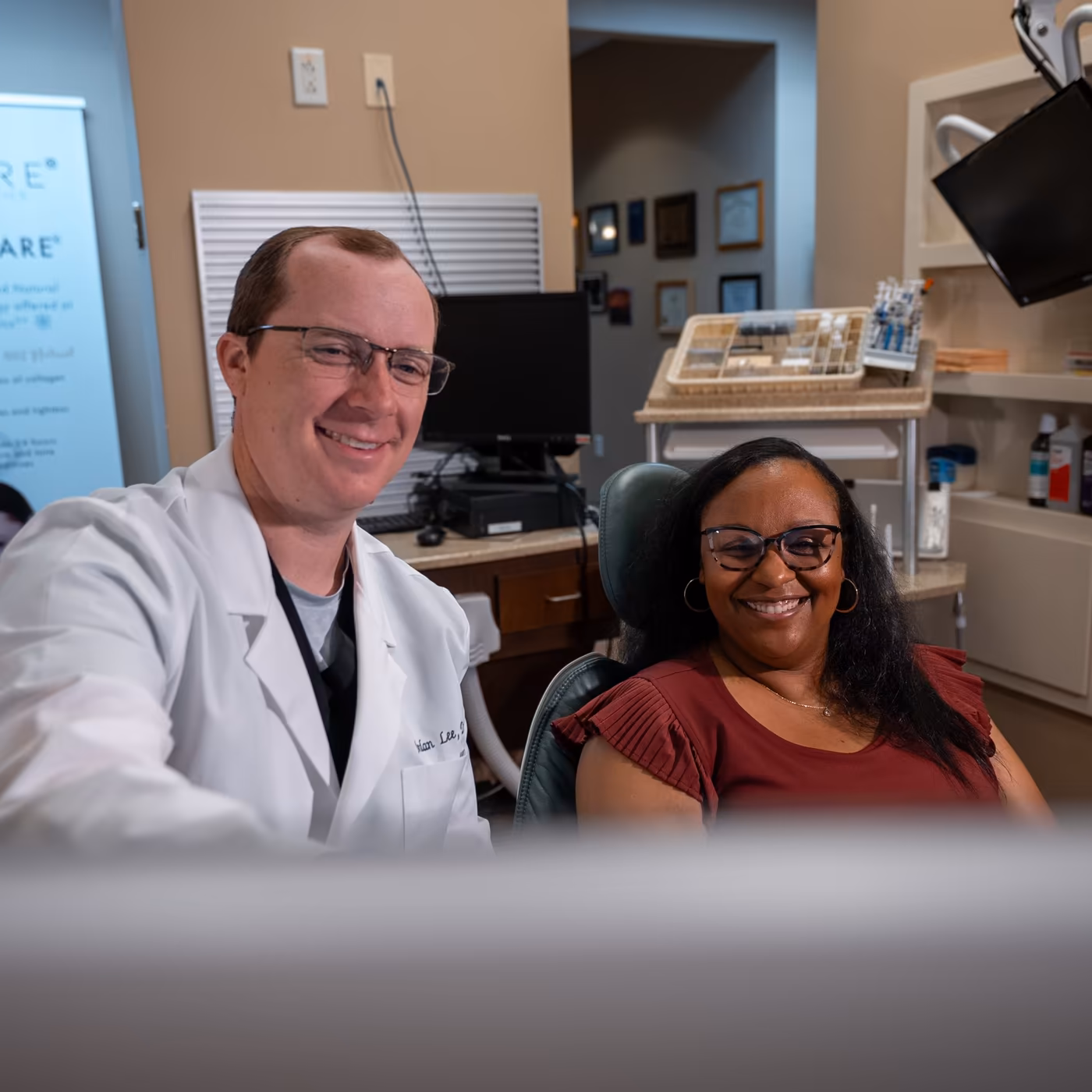 Dr. Jordan Lee sitting with a smiling patient in a treatment room at Smiles of Cary