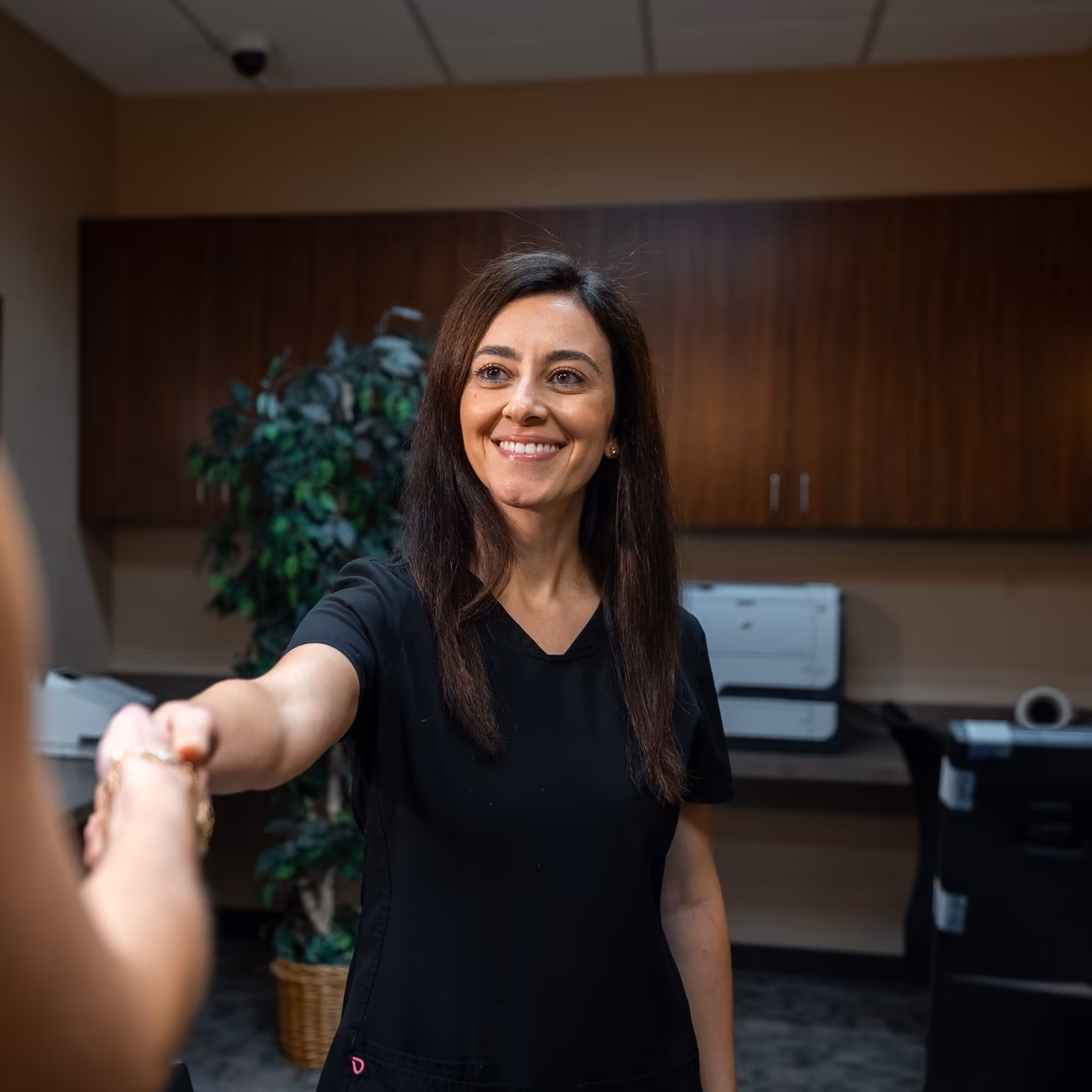 A team member welcoming a patient at the front desk of Smiles of Cary