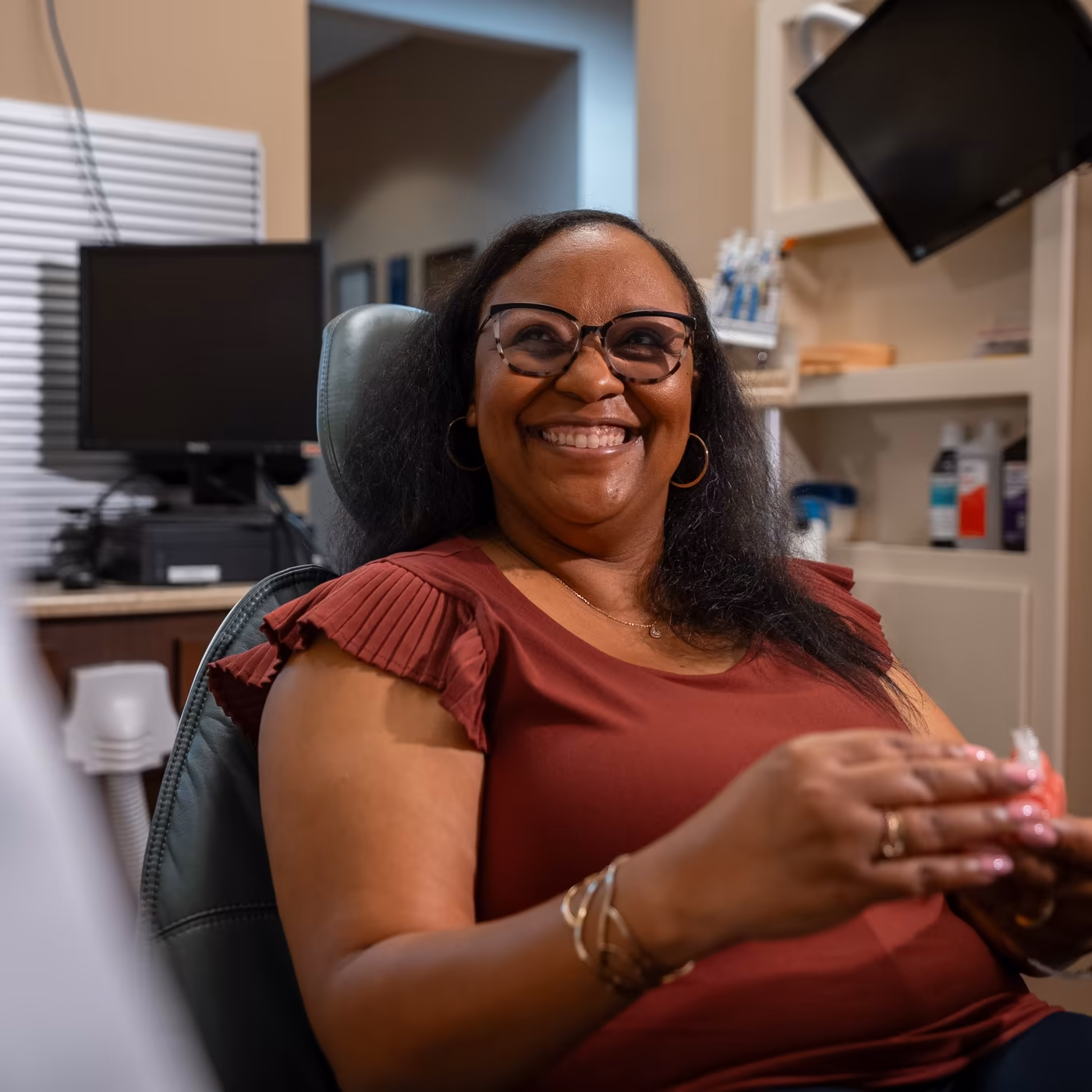 A smiling patient holding a dental model during her visit to Smiles of Cary
